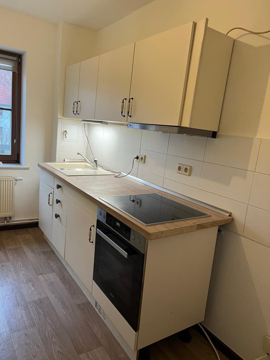 Fertig montierte Küchenzeile mit Arbeitsplatte, Spüle, Kochfeld, Backofen und Hängeschränken